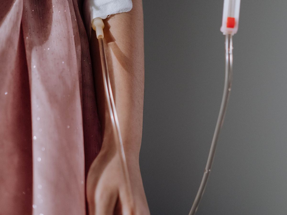 Une perfusion posée en cabine, la ligne de soin devant une tenture claire